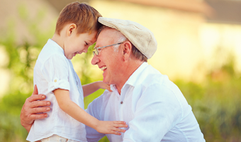 Zwei glückliche Menschen. Opa und Enkelsohn lachen und umarmen sich. Das ZBFS ist die Behörde für alle Generationen.