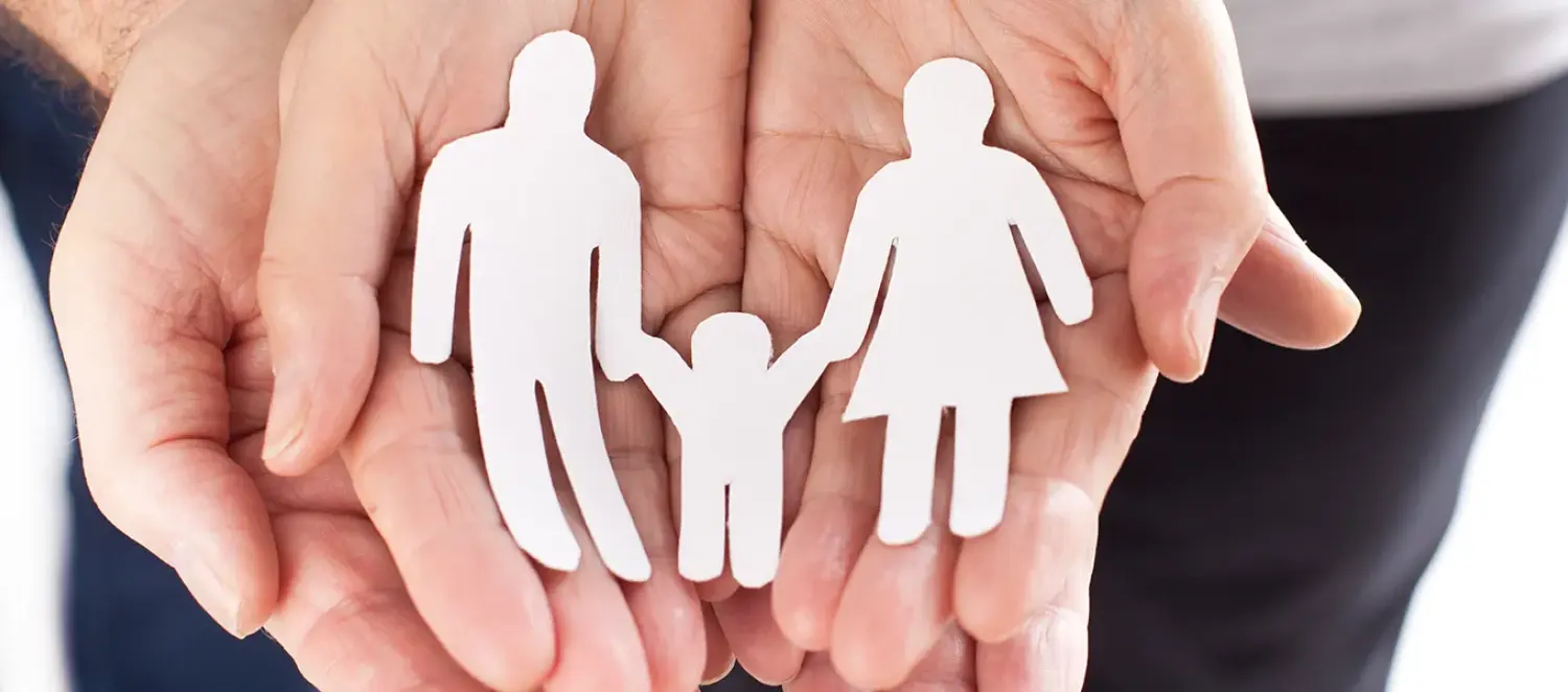 Hände halten einen Familie aus Papier 