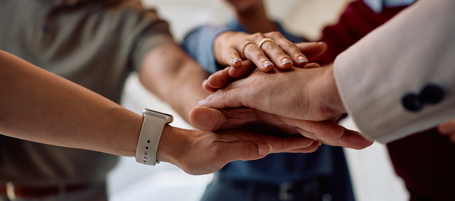 Fokus auf Händen von Arbeitskollegen, die zusammen einen Erfolg feiern