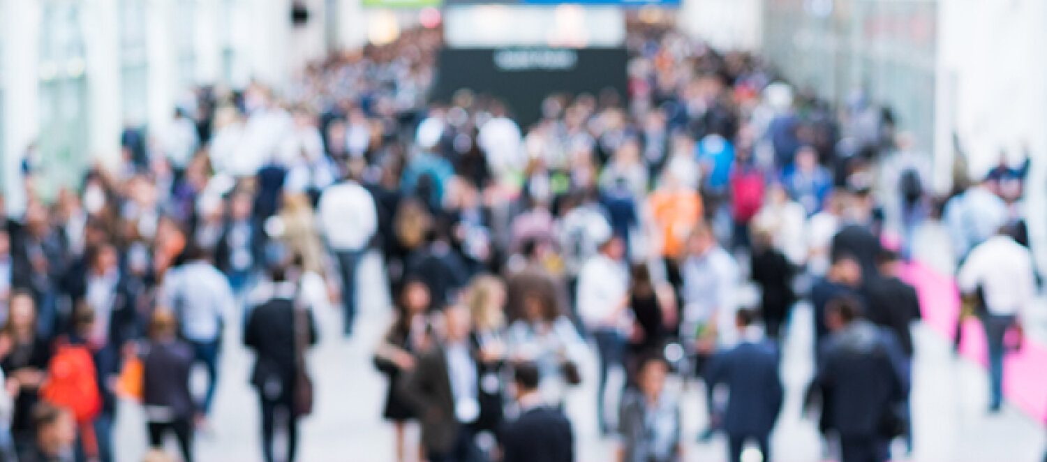 Menschen laufen auf einer Messe herum
